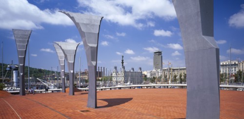 SPAIN, Catalonia, Barcelona, Port Vell.  Modern sculpture on paved area with masts of moored yachts
