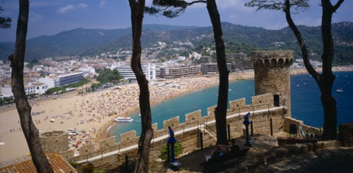 SPAIN, Catalonia, Tossa de Mar, View over busy sandy beach and town from fortified walls of Villa