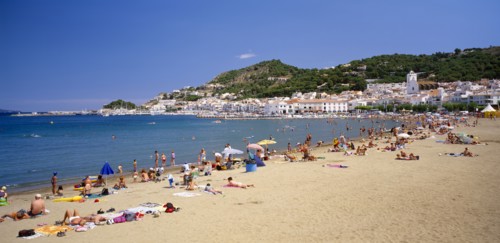 SPAIN, Catalonia, El Port de La Selva, "Curved, sandy beach with people sunbathing and in the water