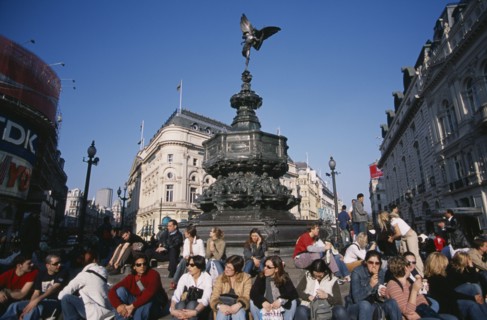 ENGLAND, London, Piccadilly Circus with mixed young crowd congregated around base of Alfred