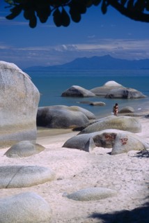 MALAYSIA, Penang, Batu Ferringhi, "Sandy beach with woman in bikini walking out of sea between