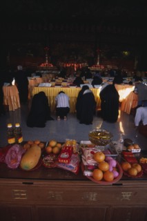 MALAYSIA, Penang, Kek Lok Si Temple, Morning prayers in the main prayer hall. Kneeling worshippers