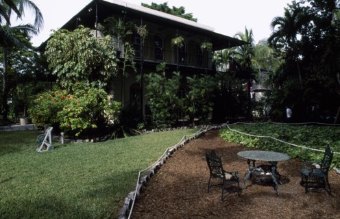 USA, Florida, Key West , "Hemmingway’s home, exterior and garden with iron table and cats asleep on