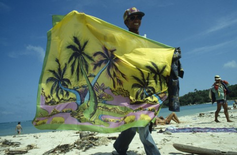THAILAND, Koh Samui, Chaweng Beach , Sarong Vendor displaying colourful sarong on the beach