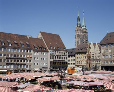 GERMANY, Bavaria, Nuremberg, The Hauptmarkt. Market stalls with red and white striped canopies in