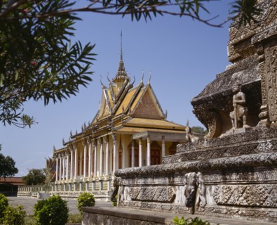 CAMBODIA, Phnom Penh, Silver Pagoda.  Exterior with ornate golden roof with spire and stone