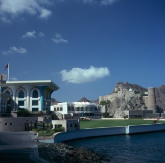 OMAN, Capital Area, Muscat, Al Alam Palace. Mosque in foreground with Fort Mirani behind