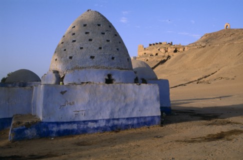 EGYPT, Upper Egypt, Aswan, Blue painted Beehive Mausoleum with Tomb of the Nobles on hilltop behind