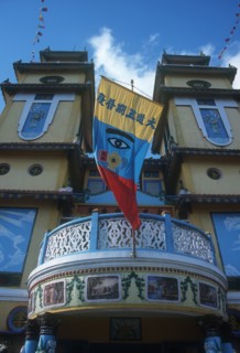 VIETNAM, An Long, Cao Dai Temple.  Detail of front portico and banner featuring the Divine Eye