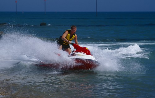 20002912 SPORT Watersports Jet Ski Man riding a jet ski on the sea at Littlehampton in West Sussex  England.