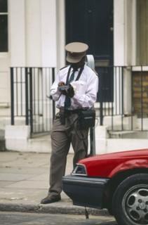 ENGLAND, London, Illegally parked car being giver parking ticket by traffic warden