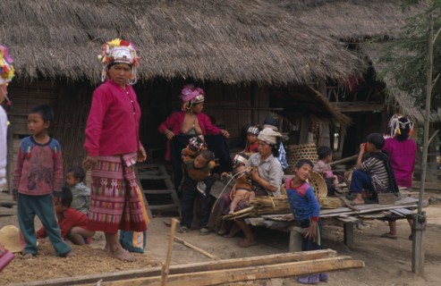 LAOS, North, Akha hilltribe women and children outside hut