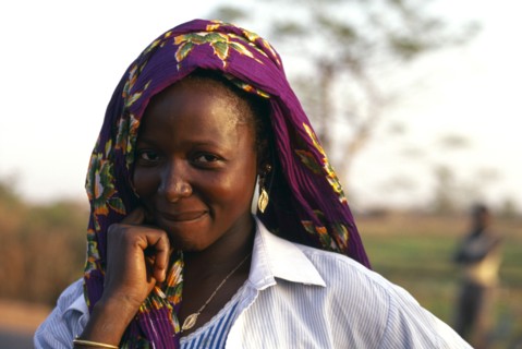 BURKINA FASO, Bobo Dioulassou, "Portrait of a smiling woman wearing a purple headscarf, working in