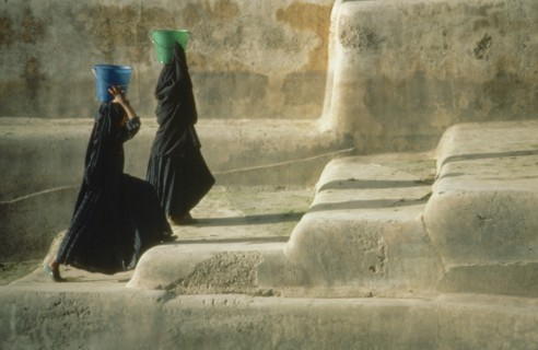 YEMEN, Shaharah, "Two veiled women fetching water carrying buckets on their heads, walking up steps