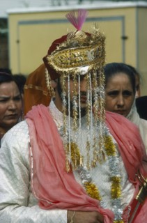 INDIA, Religion, Wedding, Portrait of  Sikh Bridegroom with gold and silver veil over his face.