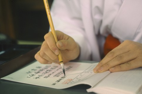 JAPAN, Honshu, Tokyo, Meiji Jingu Temple with detail of Shinto calligrapher at work