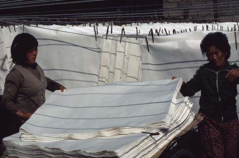 SOUTH KOREA, Crafts, Women stacking sheets of hand-made mulberry paper used for door and window