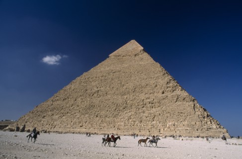 EGYPT, Cairo Area, Giza, Pyramid of Khufu with horse and donkey renters passing by