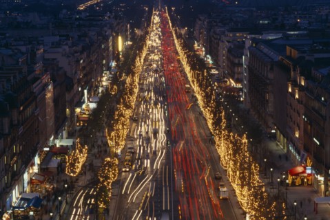FRANCE, Ile de France, Paris, Les Champs Elysees at night with illuminated shop fronts and traffic
