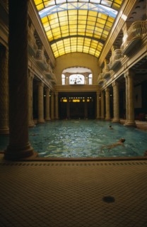HUNGARY, Budapest, Gellert Baths.  Interior with bathers in swimming pool lined with carved pillars