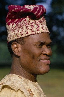 NIGERIA, Portraits, Men, Yoruba chief.  Portrait wearing hat and robe.
