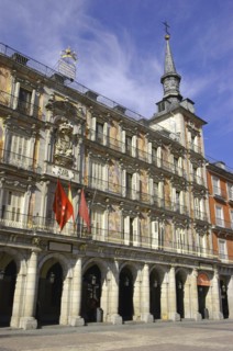SPAIN, Madrid, Plaza Mayor with flags hanging over archways and spire above
