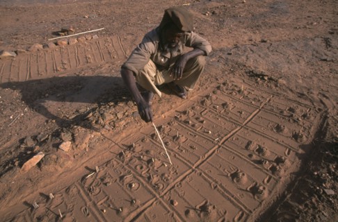 MALI, Pays Dogon, Bongo, A Dogon sand diviner indicating fox paw prints for telling fortunes.