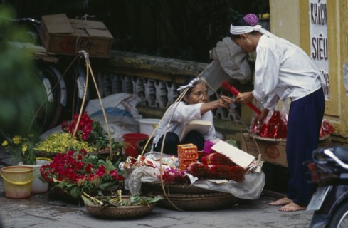 VIETNAM, North, Hanoi, Woman selling religious offerings from the pavement outside a temple