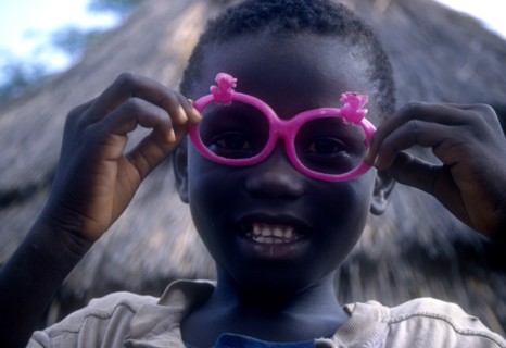 ETHIOPIA, Children, Portrait of a young Dimma Sudanese boy with pink sunglasses