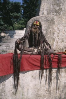NEPAL, Kathmandu Area, Portrait of a Saddhu with excessively long hair sitting outside