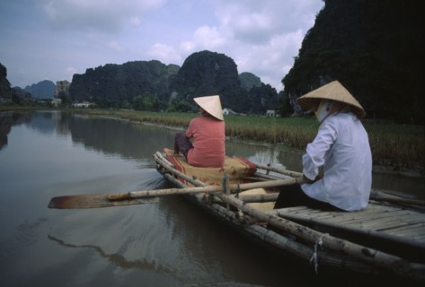 VIETNAM, North, Hoa Lu, Two women rowing bamboo canoe.