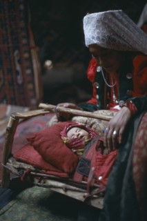 AFGHANISTAN, People, Kirghiz woman with baby inside yurt.
