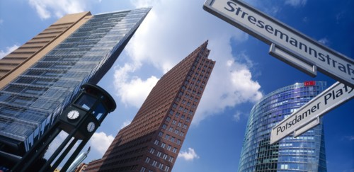 GERMANY, Berlin, Angled view of the city skyscrapers and clock with a sign post for Potsdamer Platz