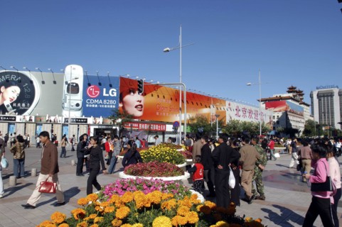 CHINA, Beijing, Busy commercial shopping area with flower pots in the foreground