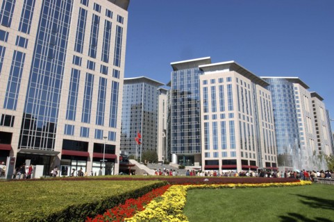 CHINA, Beijing, Modern city architecture with red and yellow flowerbeds in the foreground