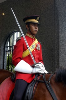 MALAYSIA, Kuala Lumpur, Uniformed guard on horseback with sword at the Kings Palace