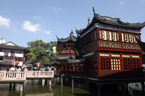 CHINA, Shanghai, Yuyuan Gardens. Bridge leading to traditional style architecture built on stilts