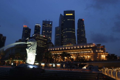 SINGAPORE, , Merlion statue spouting water illuminated against a night time city skyline