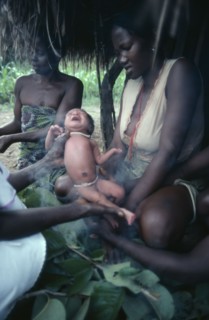 SUDAN, People, Azande women and child during ritual purification of new born baby in smoke.