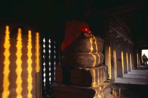 CAMBODIA, Siem Reap, Angkor Wat, Buddha statue in gallery on the third level at sunset