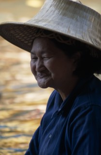 THAILAND, South, Bangkok, Damnoen Saduak Floating Market portrait of an old female vendor wearing a