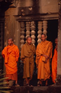 CAMBODIA, Siem Reap Province, Angkor Wat, Buddhist monks standing in front of window of upper level
