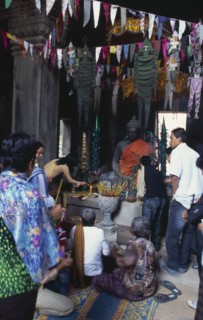CAMBODIA, Siem Reap Province, Angkor, Banteay Kdei.  Cambodian visitors lighting incense at shrine