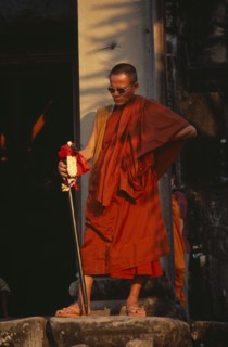 CAMBODIA, Siem Reap, Angkor Wat, Buddhist monk wearing sunglasses and carrying an elaborate walking