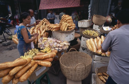 CAMBODIA, Siem Reap, Market stall selling bread and bananas with customers