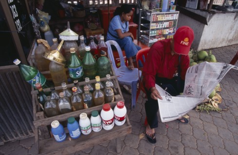 CAMBODIA, Siem Reap, Roadside stall selling bottles of petrol watered down and at the same price as