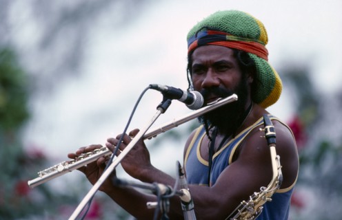 PAPUA NEW GUINEA, Port Moresby, Rastafarian musician singing and playing flute at a concert.