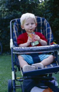 ENGLAND, West Sussex, Chichester, The Bishops Palace Gardens.  Boy aged one and a half drinking