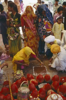 INDIA, Rajasthan, Udaipur, Mourners at memorial service for recently deceased man. Pots covered