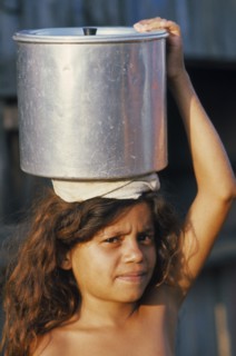 BRAZIL, Tribal People, Young girl carrying pot of water on her head.